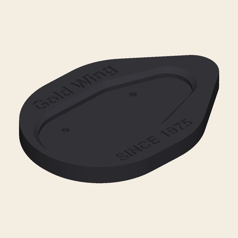 A teardrop-shaped 3D-printed Honda Gold Wing side-stand pad with a tapered recessed foot cradle, Gold Wing and SINCE 1975 etched on top, and a grab tab