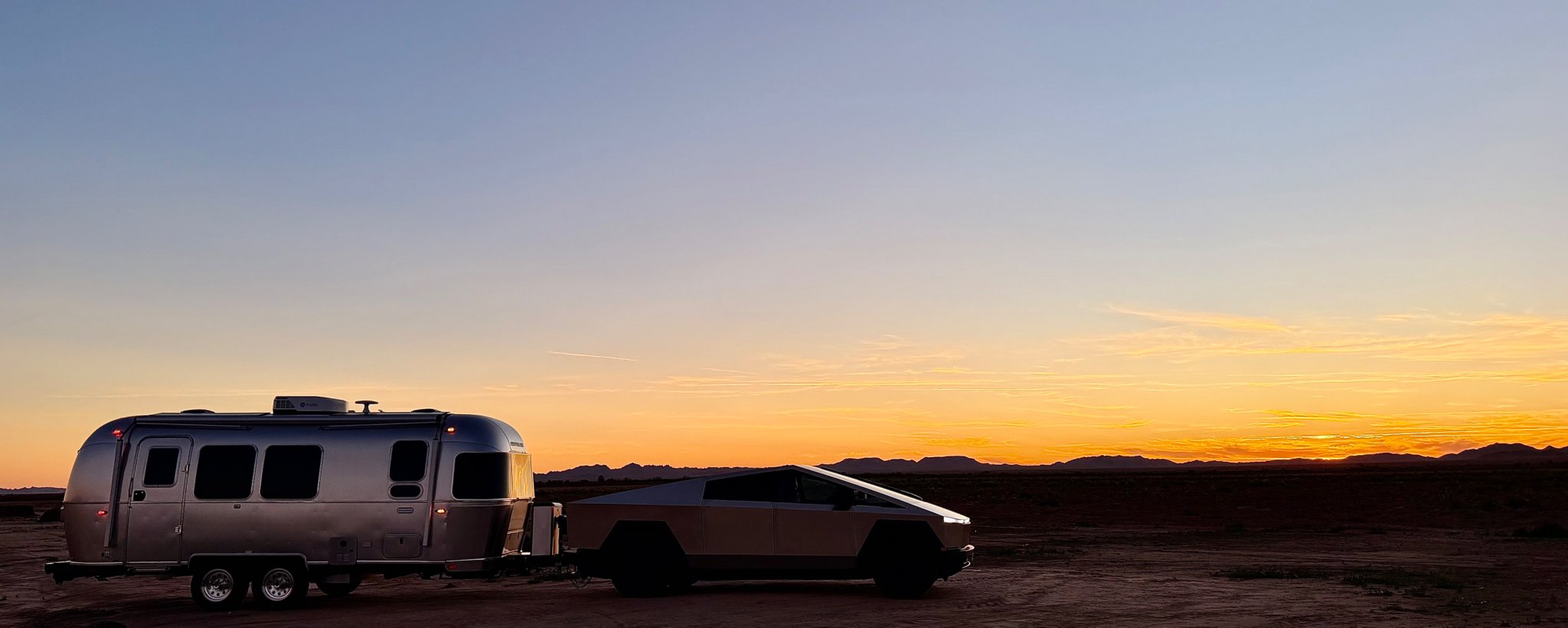 Cybertruck towing the silver 23-foot Airstream International on a desert road during the Arizona towing trip