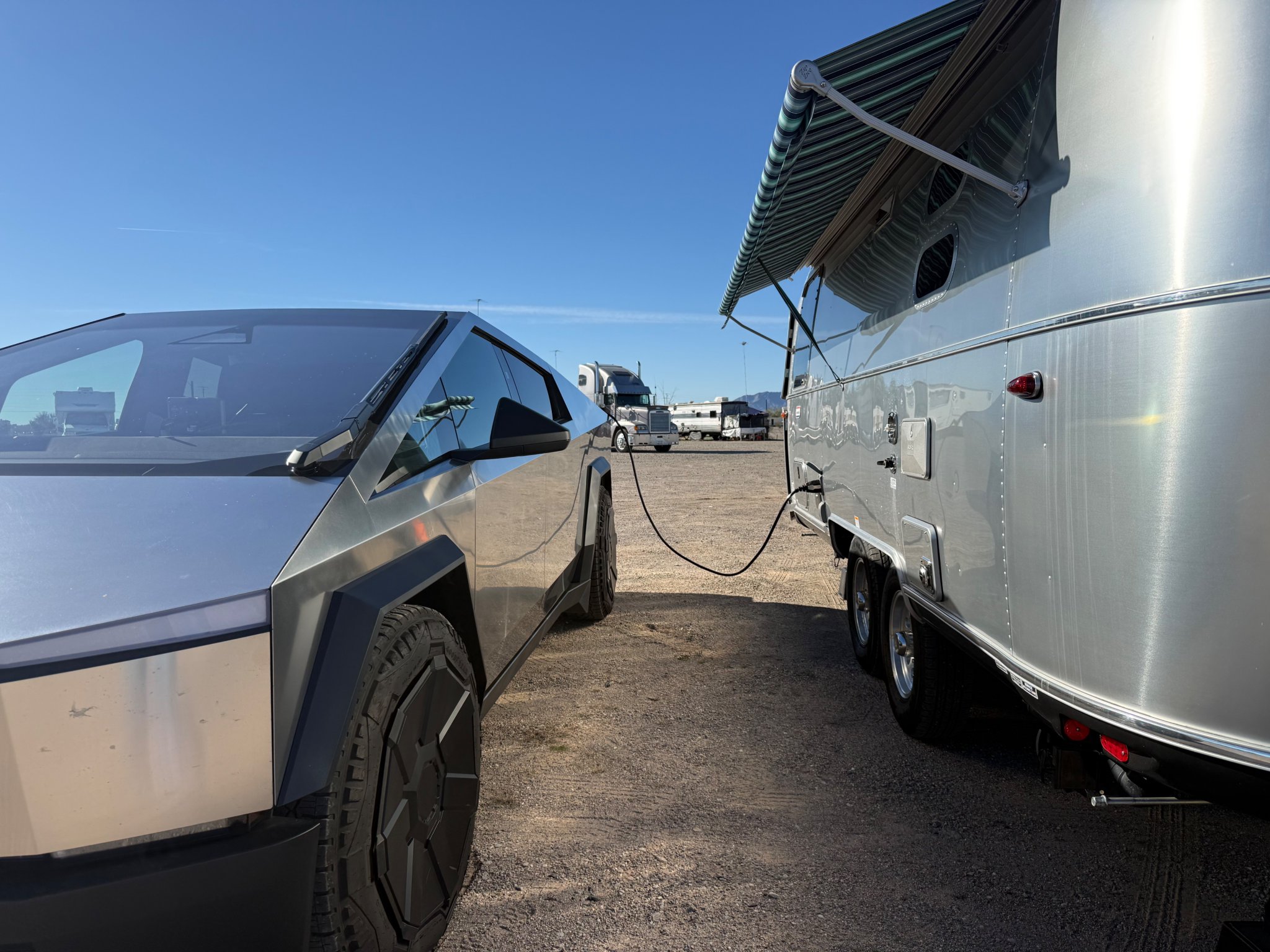 Cybertruck hitched to the Airstream International under a bright desert sky