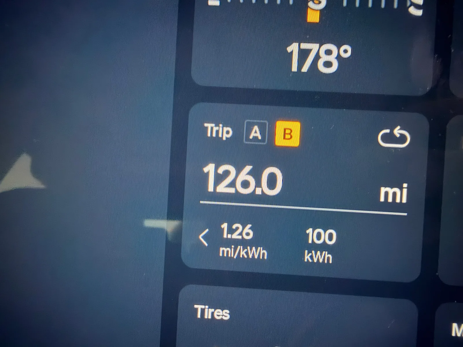 The Rivian R1T's center display close-up at Dateland showing the Trip B counter at 126.0 miles, 1.26 mi/kWh efficiency, 100 kWh used, and a 178-degree compass heading