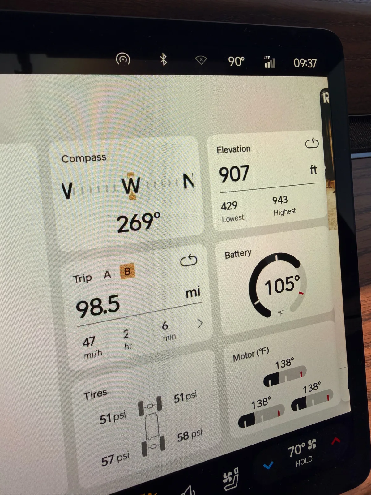 The Rivian R1T center display at Estrella showing Trip B 98.5 miles at 47 mph average over 2 hours 6 minutes, 1.18 mi/kWh efficiency, 83 kWh used, elevation 907 ft (lowest 429, highest 943), compass 269 degrees west, motor temps 138°F, ambient 90°F