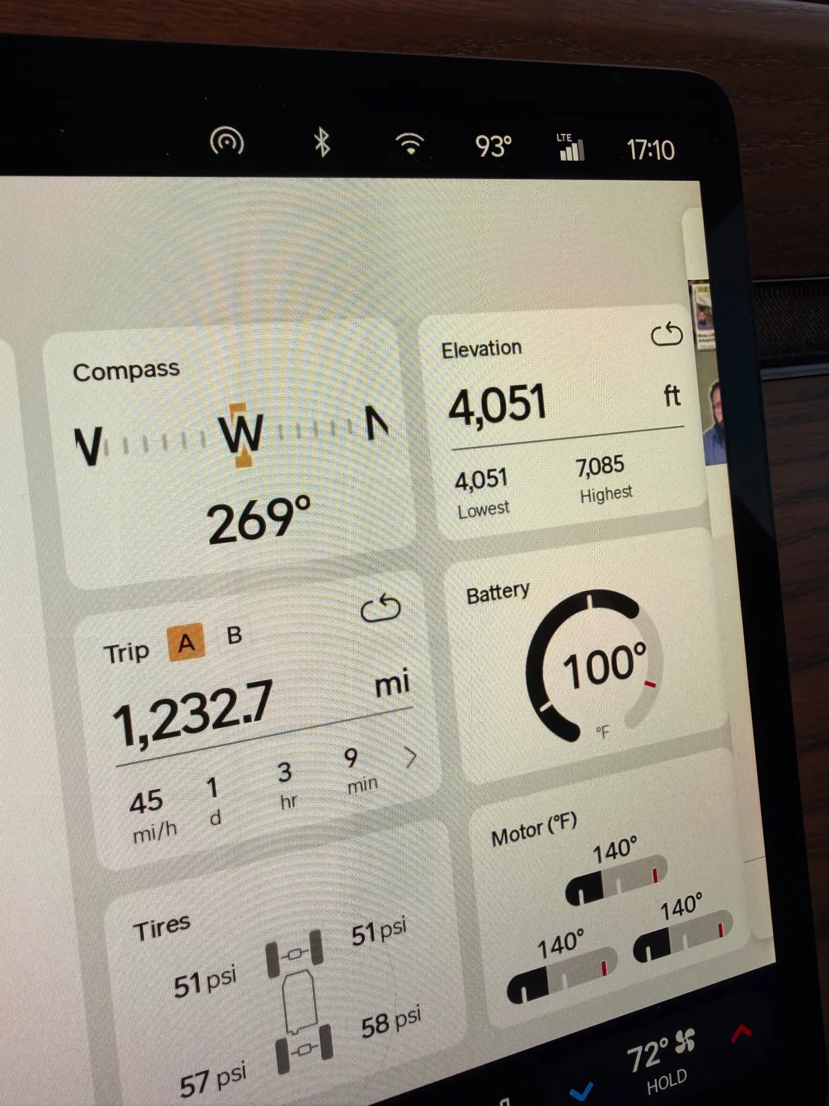 The Rivian R1T center display at the Tucumcari IONNA Rechargery at 5:10 PM showing Trip A 1,232.7 miles at 45 mph average over 1 day 3 hours 9 minutes, elevation 4,051 ft (lowest 4,051, highest 7,085 ft at Clines Corners), compass W 269 degrees, battery 100°F, motor temps 140°F all four, tires 51 to 58 psi, ambient 93°F