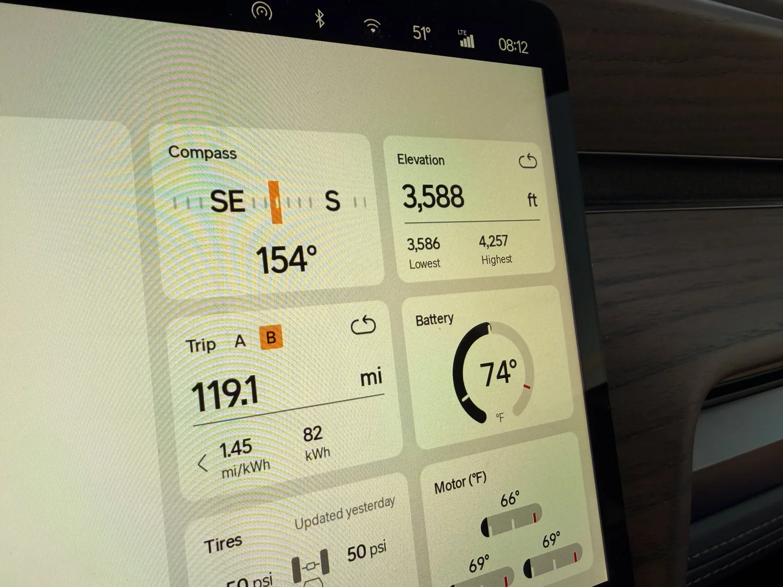The Rivian R1T center display at the Amarillo KOA at 8:12 AM CDT showing Trip B 119.1 miles at 1.45 mi/kWh and 82 kWh used since Tucumcari, elevation 3,588 ft (lowest 3,586, highest 4,257), battery 74°F, motor temps 66 to 69°F cold start, tires 50 psi, ambient 51°F