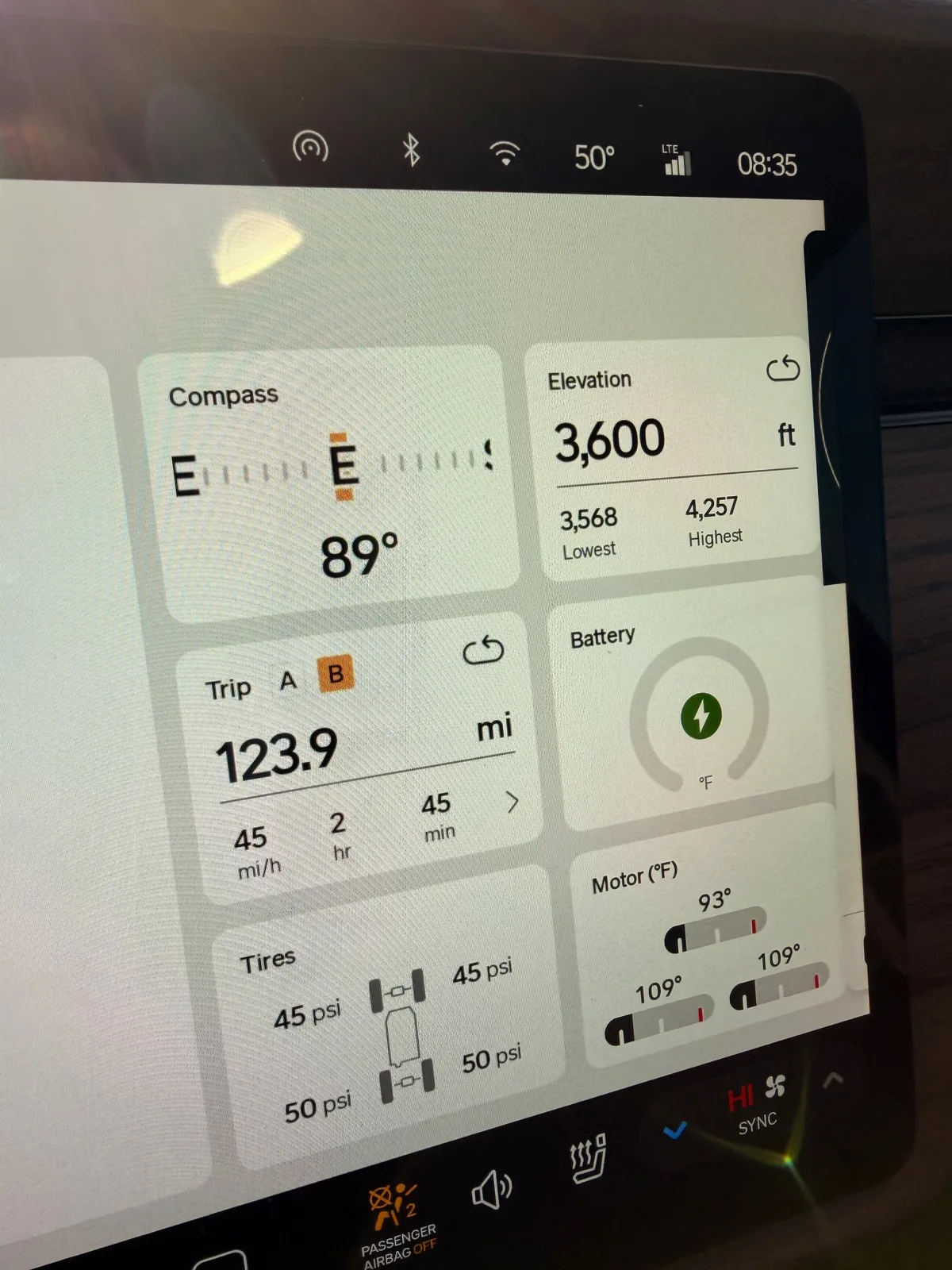 The Rivian R1T center display at the Buc-ee's Amarillo Tesla Supercharger at 8:35 AM CDT showing Trip B 123.9 miles at 45 mph over 2 hours 45 minutes since the Tucumcari unplug, battery charging, motor temps 93 to 109°F warming, ambient 50°F
