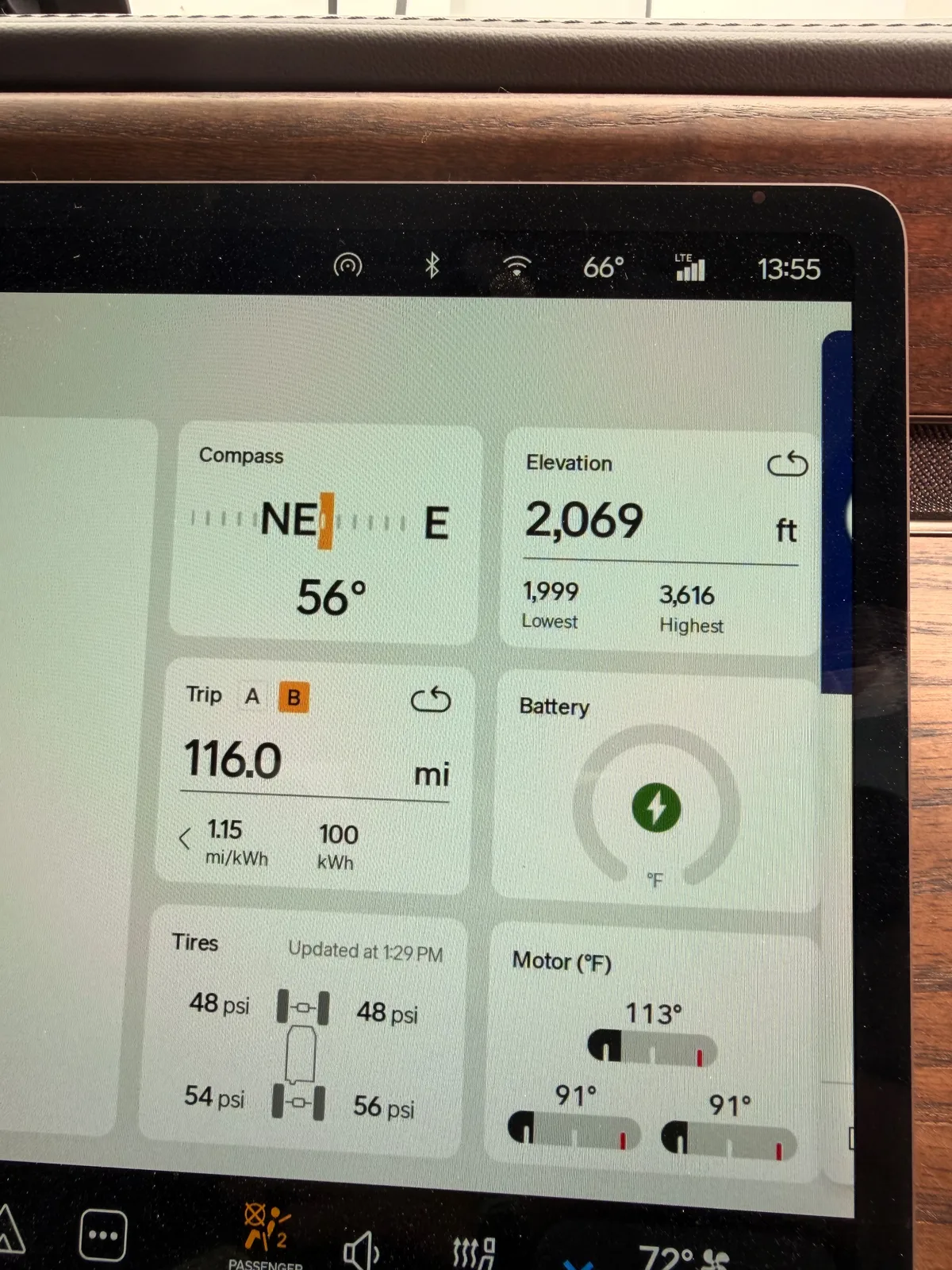 The Rivian R1T center display at the Erick OK Electrify America station at 1:55 PM CDT showing Trip B 116.0 miles at 1.15 mi/kWh and 100 kWh used since Buc-ee's Amarillo, elevation 2,069 ft (lowest 1,999, highest 3,616), battery charging, motor temps 91 to 113°F, tires 48 to 56 psi, ambient 66°F