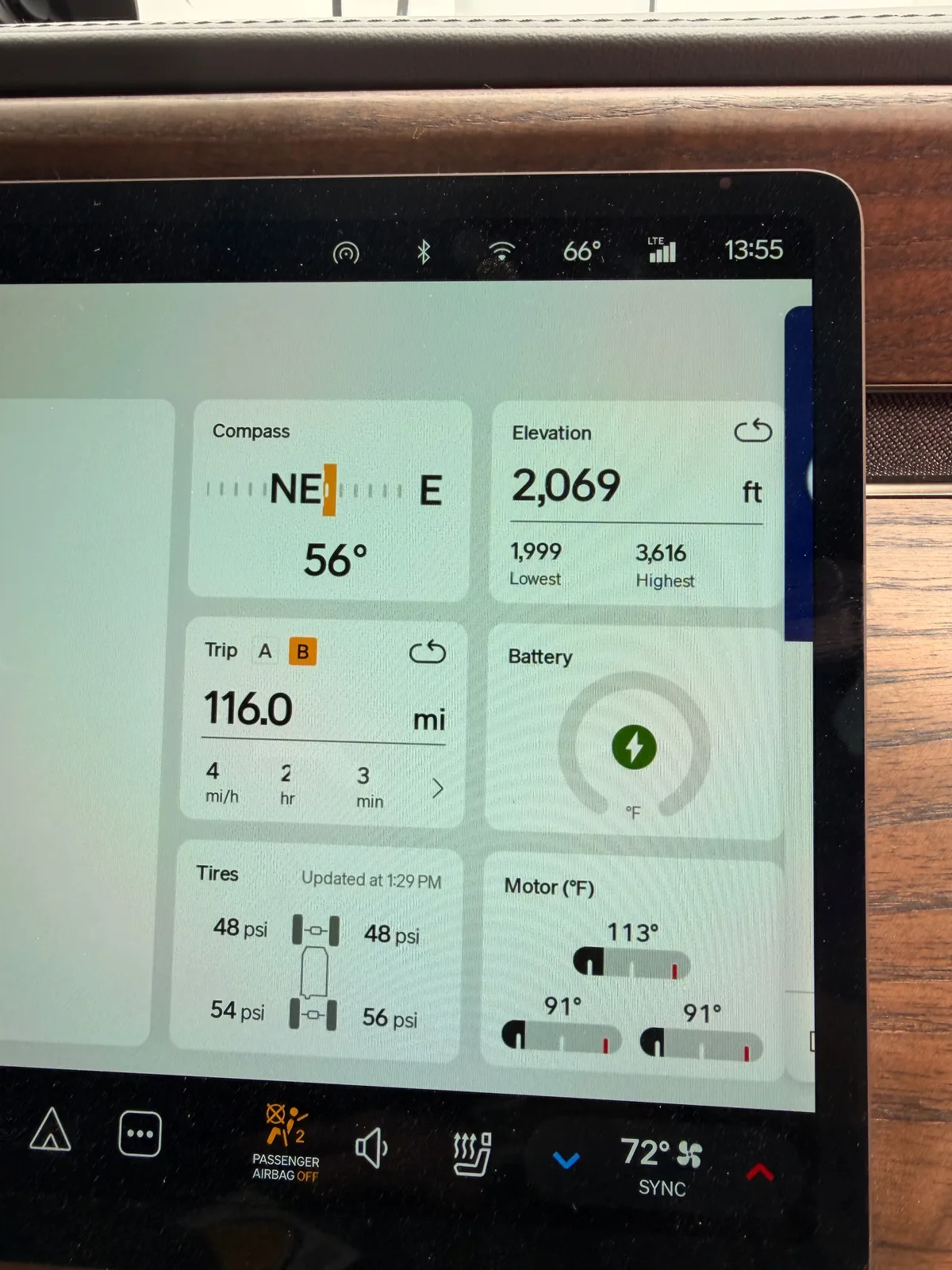 The Rivian R1T center display Trip B time view at Erick OK at 1:55 PM showing 116.0 miles, battery charging, motor temps 91 to 113°F, elevation 2,069 ft, descended ~1,600 ft from Amarillo plateau into the OK plains