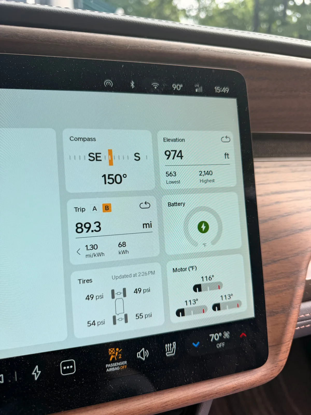 The Rivian R1T center display Trip B view at Indian Point showing the Lowell-to-Branson leg, 89.3 miles at 1.30 mi/kWh and 68 kWh used, elevation 974 ft, battery charging, ambient 90°F, 38 mph moving average on the leg