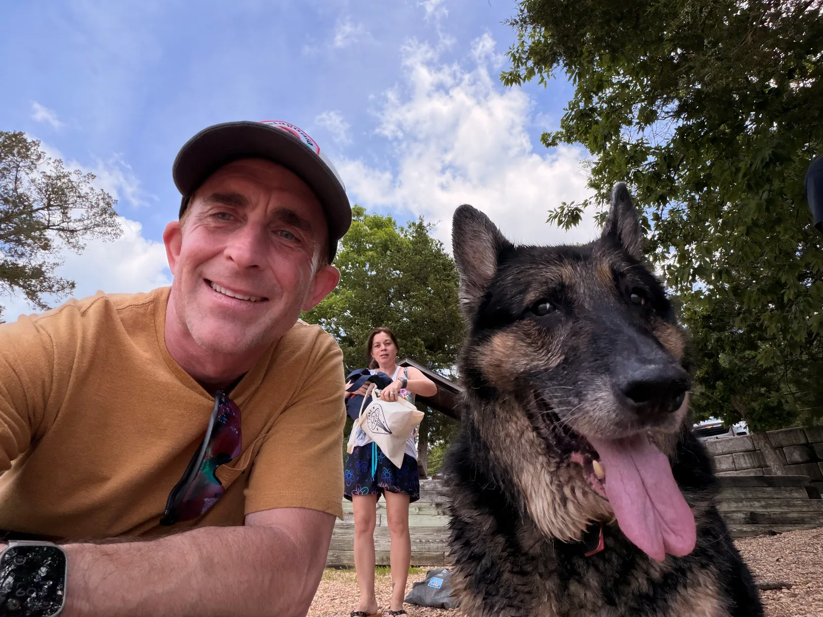 Eric in an orange shirt with Mission the German shepherd in a lakeside selfie at Table Rock, both wet from the lake