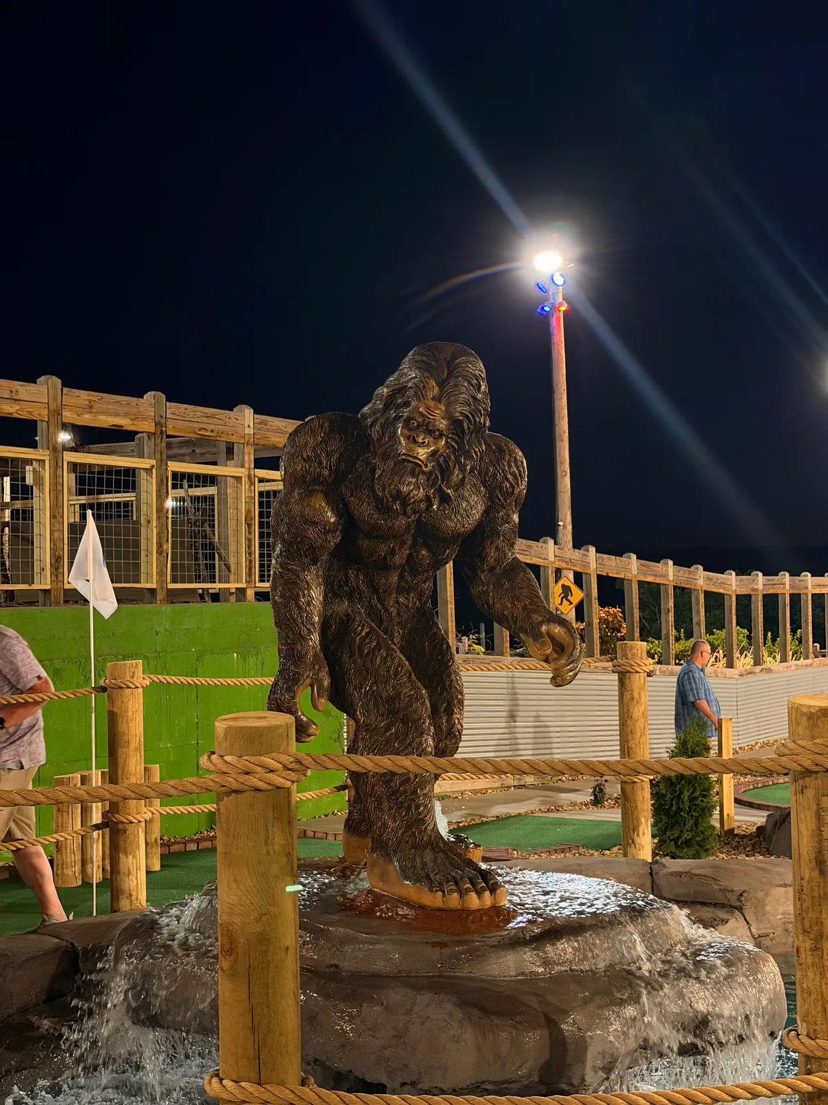 A large Bigfoot statue lit green at night at the Bigfoot Fun Park on the Branson strip