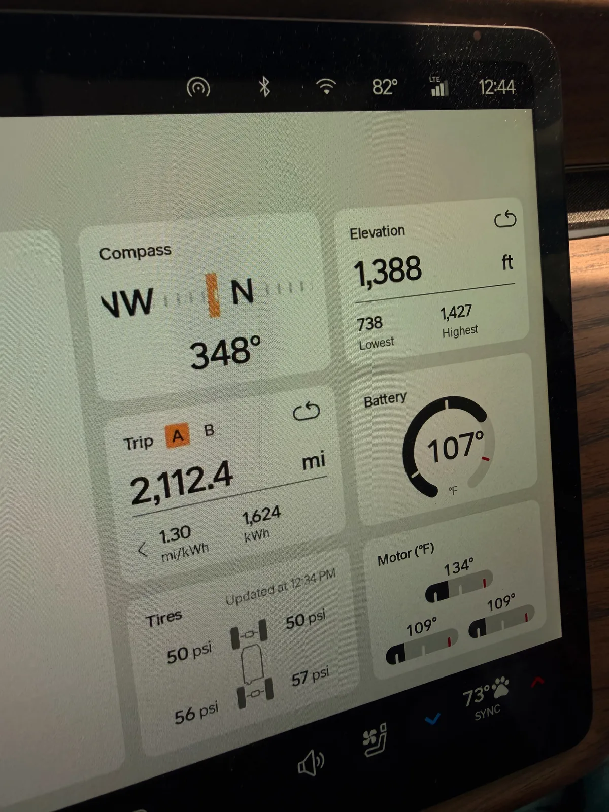 The Rivian R1T center display Trip A view at the Springfield Supercharger showing Trip A 2,112.4 miles trip-to-date, elevation 1,388 ft, battery charging, ambient 82°F