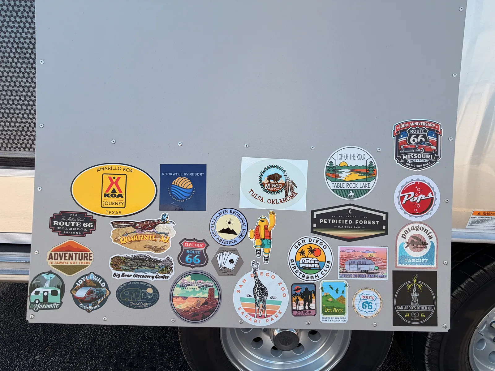 The Airstream's sticker board filling in with travel-map stickers from the trip so far