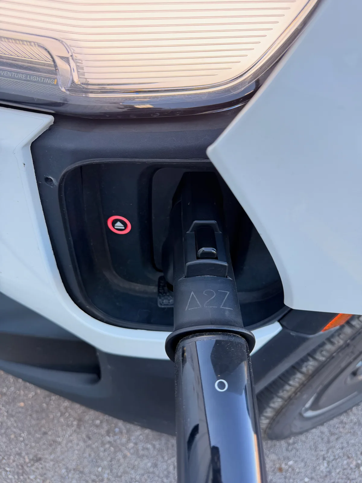 Close-up of the Rivian R1T's charge port with the LED ring glowing red, indicating a failed session start at a third-party-host Tesla Supercharger in Spring Grove, Illinois