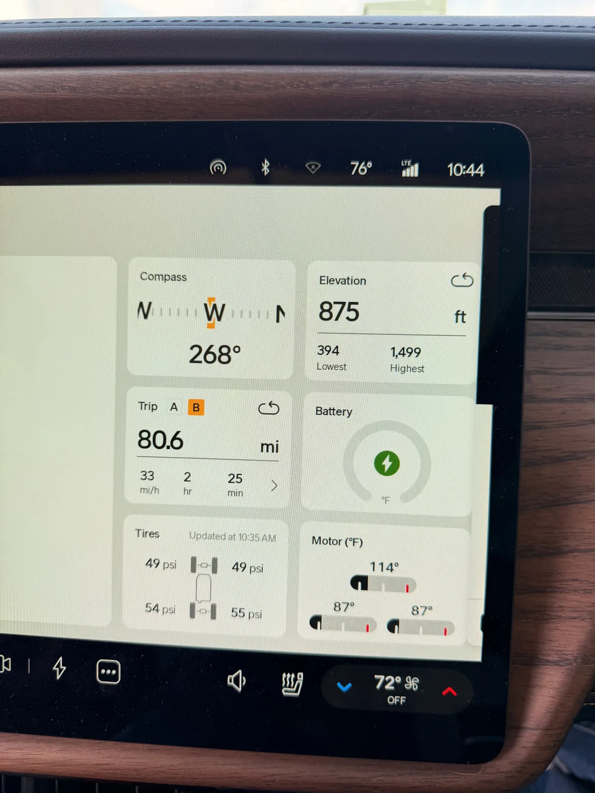 The Rivian R1T center display Trip B view at the Rockford Tesla V3 Supercharger showing 80.6 miles at 2.36 mi/kWh and 34 kWh used, elevation 875 ft, battery charging, ambient 76°F