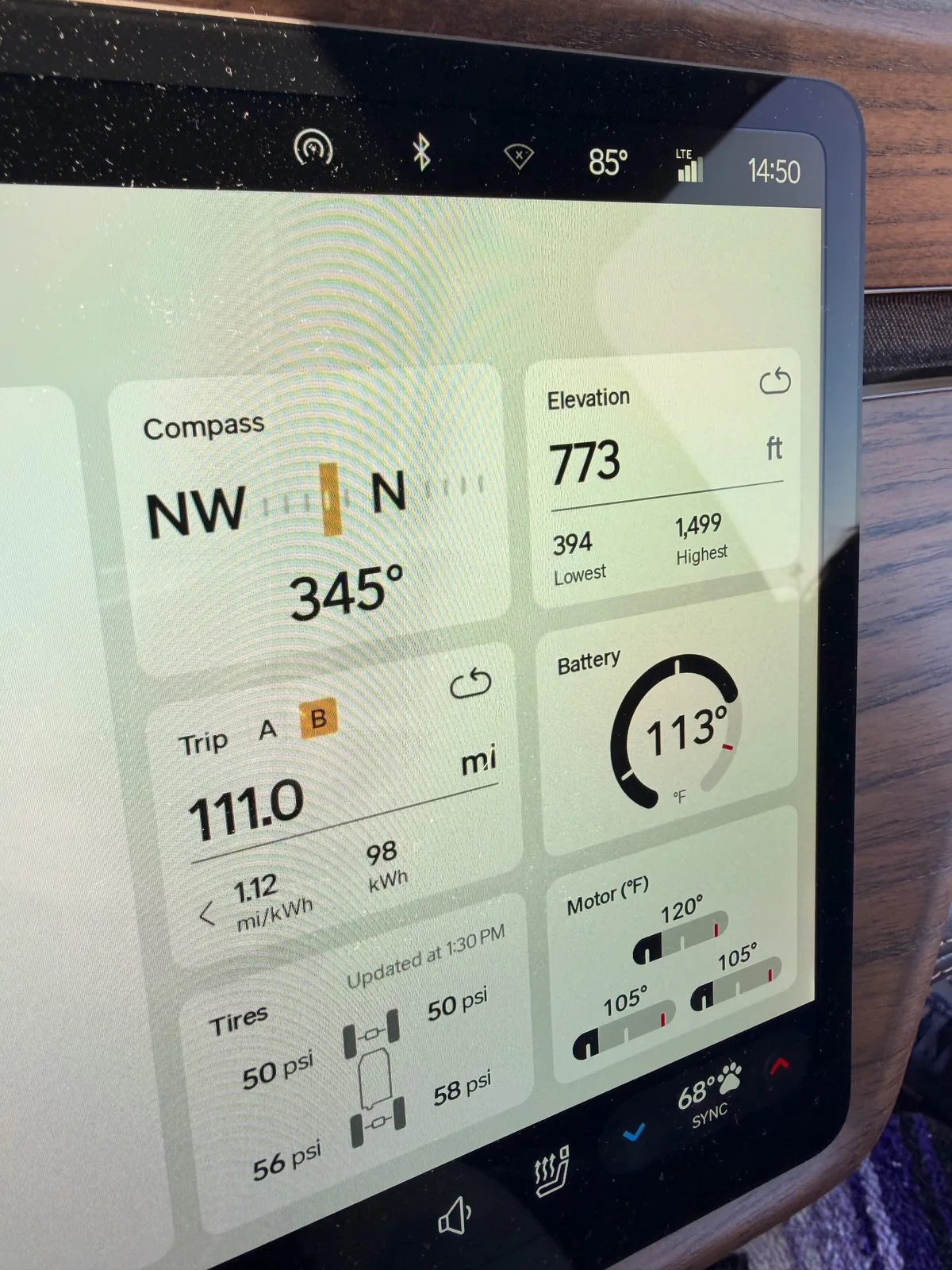 The Rivian R1T center display at the Walcott truck stop showing Trip B 111.0 miles, 1.12 mi/kWh, 98 kWh used, compass NNW, elevation 773 feet, battery 113 degrees F