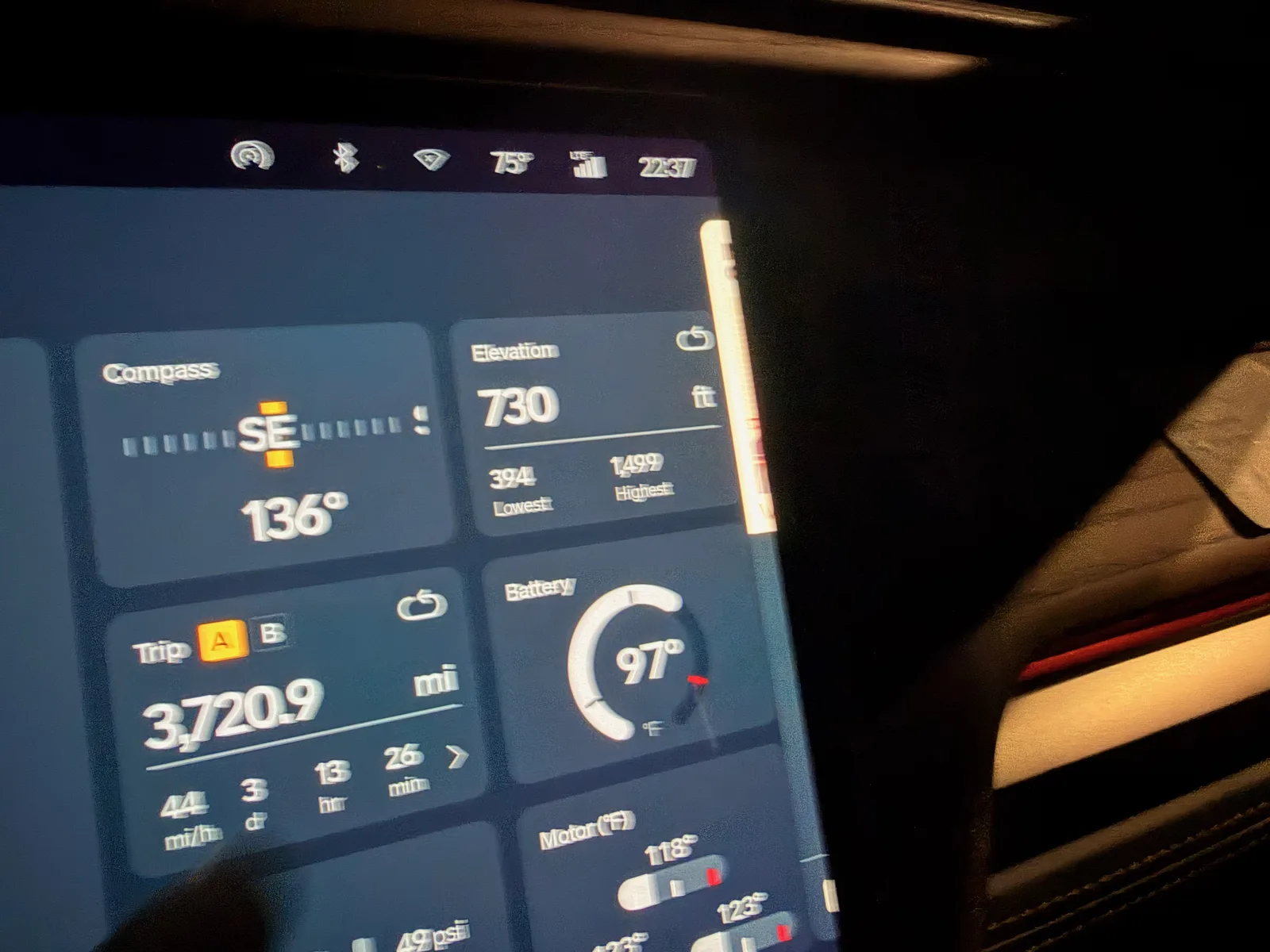 The Rivian R1T center display at the Columbia MO Rivian Adventure Network charger at night showing Trip A 3,720.9 miles, 1.32 mi/kWh, compass SE, elevation 730 feet, 75 degrees F