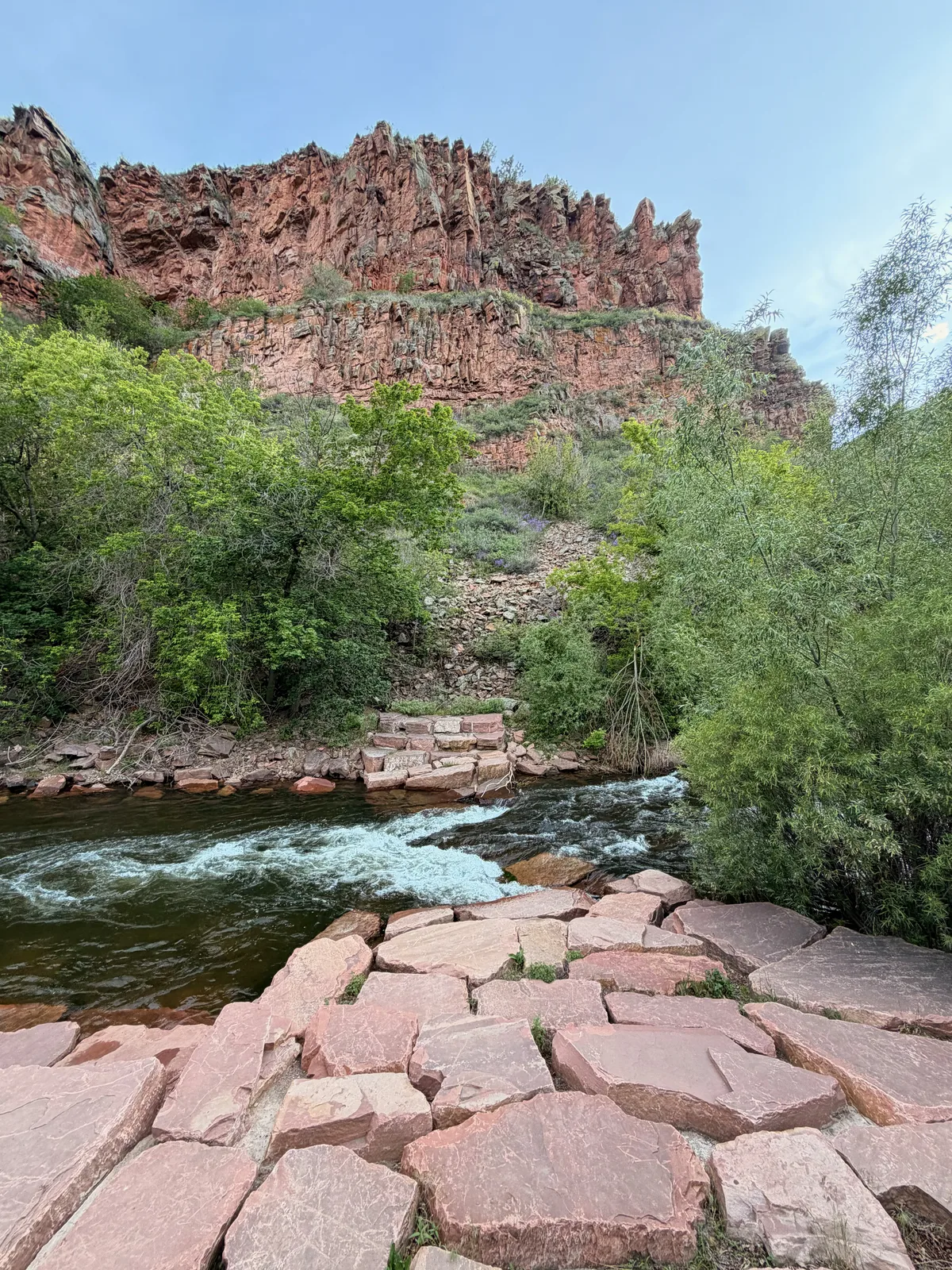 Red sandstone canyon walls and the St. Vrain Creek running past the campsites at LaVern M. Johnson Park in Lyons, Colorado