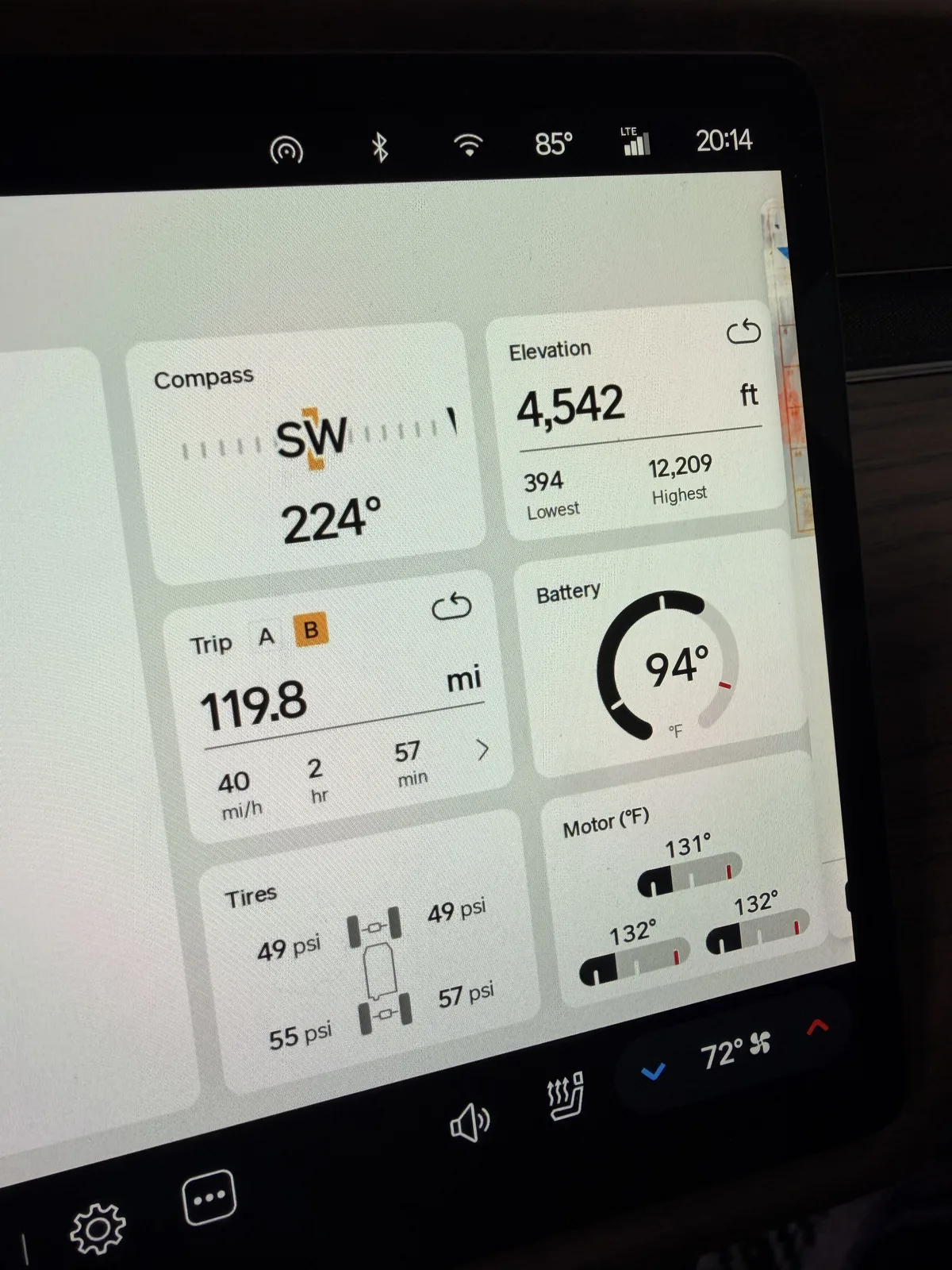 Rivian R1T center display at the Grand Junction RAN at 8:14 PM showing Trip B 119.8 miles, compass heading southwest 224 degrees, elevation 4,542 ft, battery 94 F