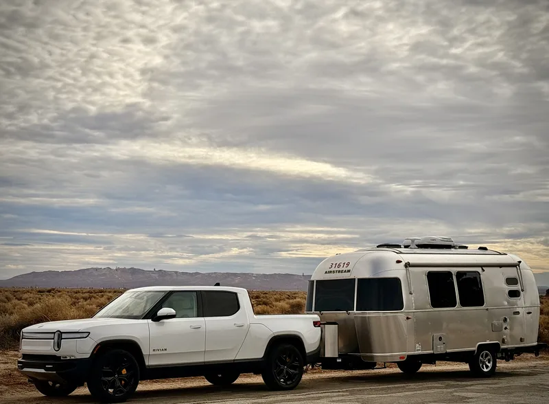 The Rivian R1T and 20-foot Airstream Caravel on the desert highway at North Edwards, California