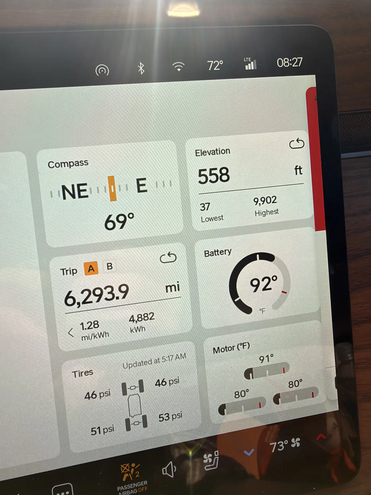 Rivian R1T center display at Airstream of San Diego at 8:27 AM reading Trip A 6,293.9 lifetime miles at 1.28 mi/kWh on 4,882 kWh, elevation 558 ft, compass NE 69 degrees, ambient 72 F, tires 46 to 53 psi
