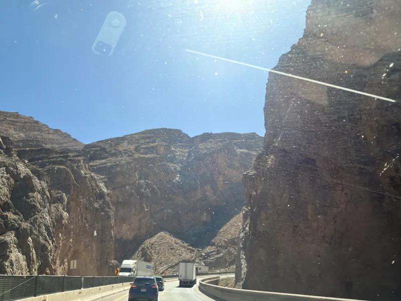 The Virgin River Gorge cliffs rising on both sides of I-15 in northwest Arizona under a deep blue sky, on the drive north to Utah