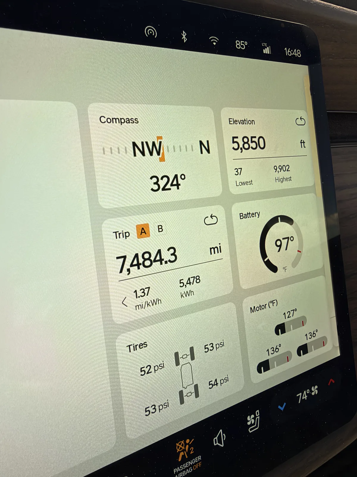 The Rivian R1T center display in Beaver, Utah showing Trip A 7,484.3 miles at 1.37 mi/kWh and 5,478 kWh cumulative, elevation 5,850 ft, motor temps 127 to 136°F, tires 52 to 54 psi, towing.
