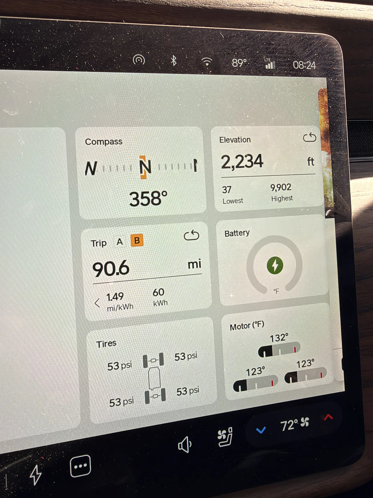 The Rivian R1T instrument display at the Las Vegas charger showing Trip B 90.6 miles at 1.49 mi/kWh and 60 kWh, elevation 2,234 ft, battery charging, motors 123 to 132°F, towing.