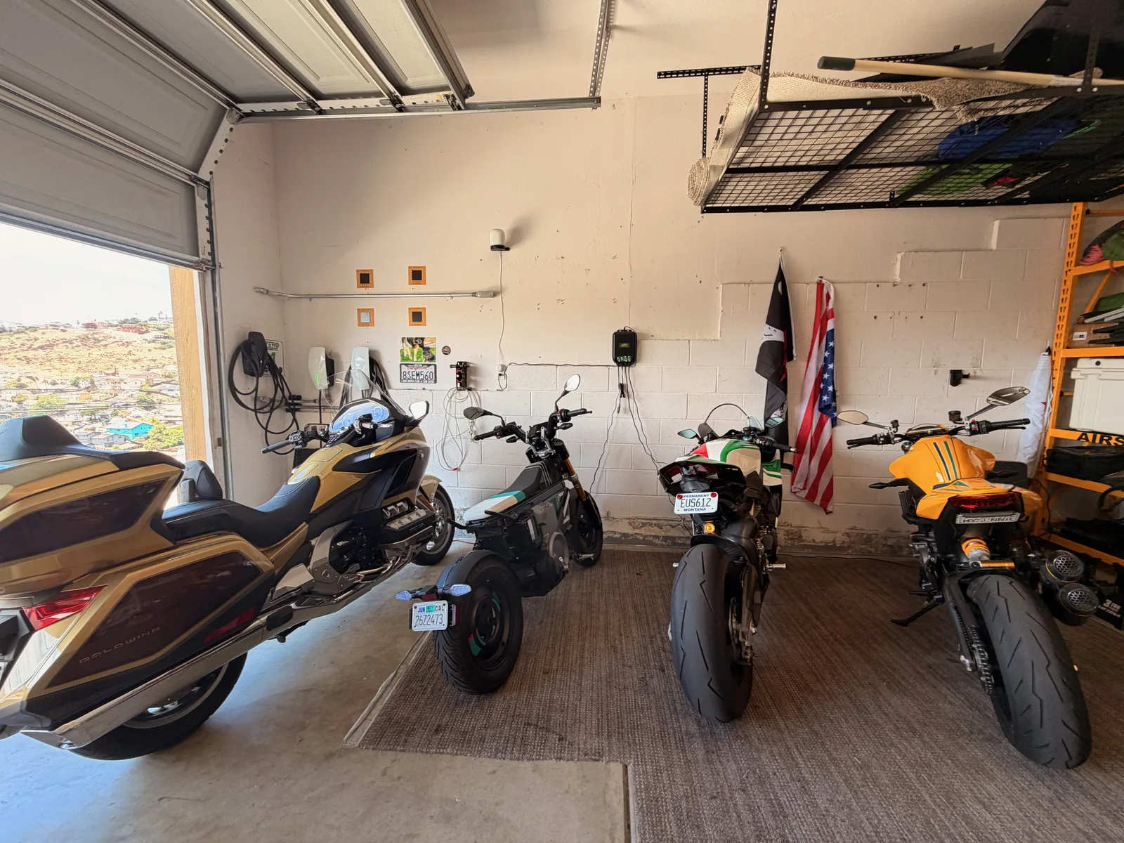 The 2025 Ducati Panigale V4 home at last in a San Diego garage, lined up with a gold Honda Gold Wing and two other motorcycles, the end of the Utah Ducati Run.