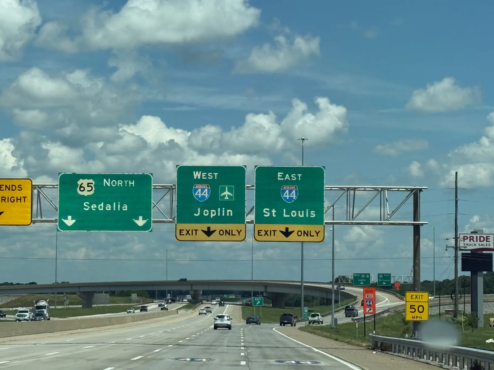 The view through the Rivian windshield approaching the I-44 interchange in Springfield, green highway signs for Joplin, St. Louis, and Springfield overhead