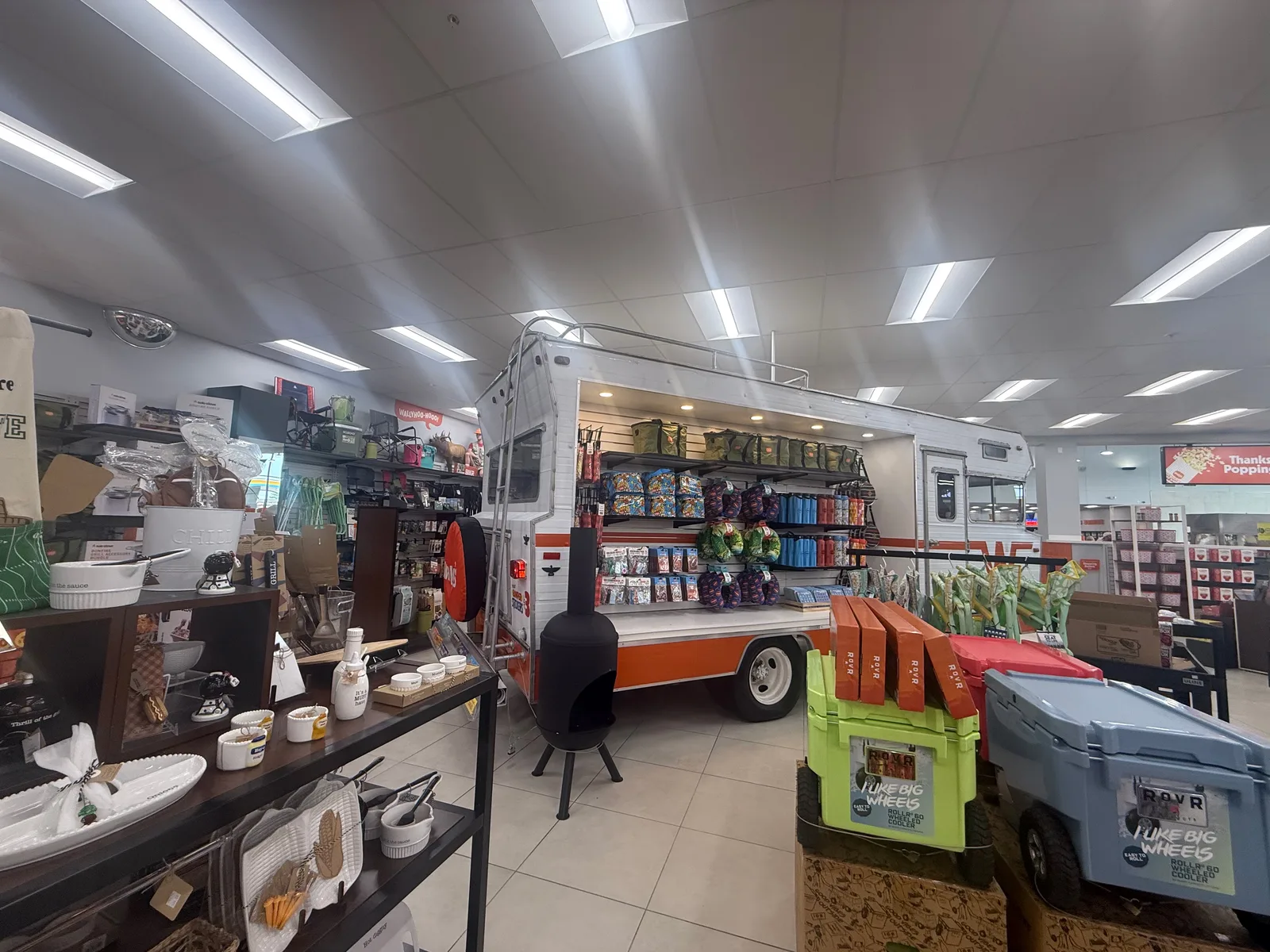 The interior of the Wally's travel center in Fenton MO, aisles of camping coolers and outdoor gear with a small camper on display