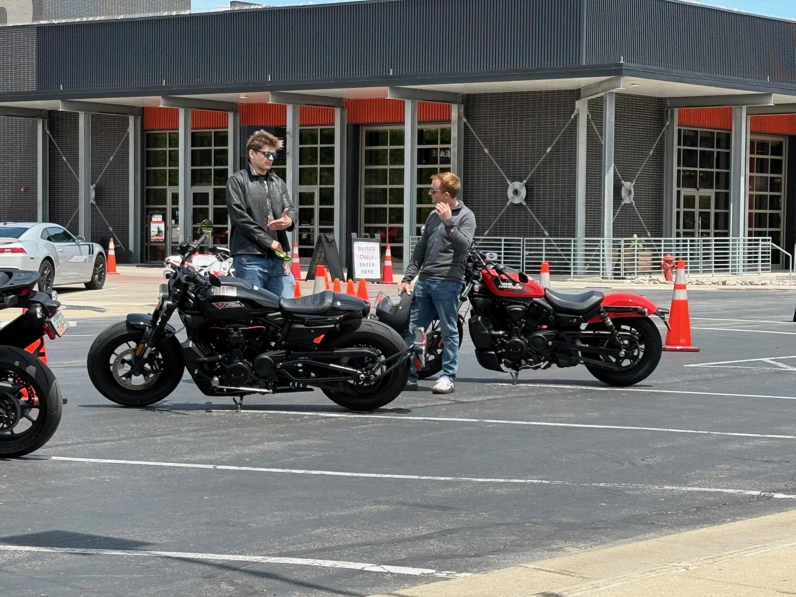 A Milwaukee-blue Harley-Davidson CVO ST Road Glide parked on the pavement in the Menomonee Valley, the old Falk works building behind it under a bright sky