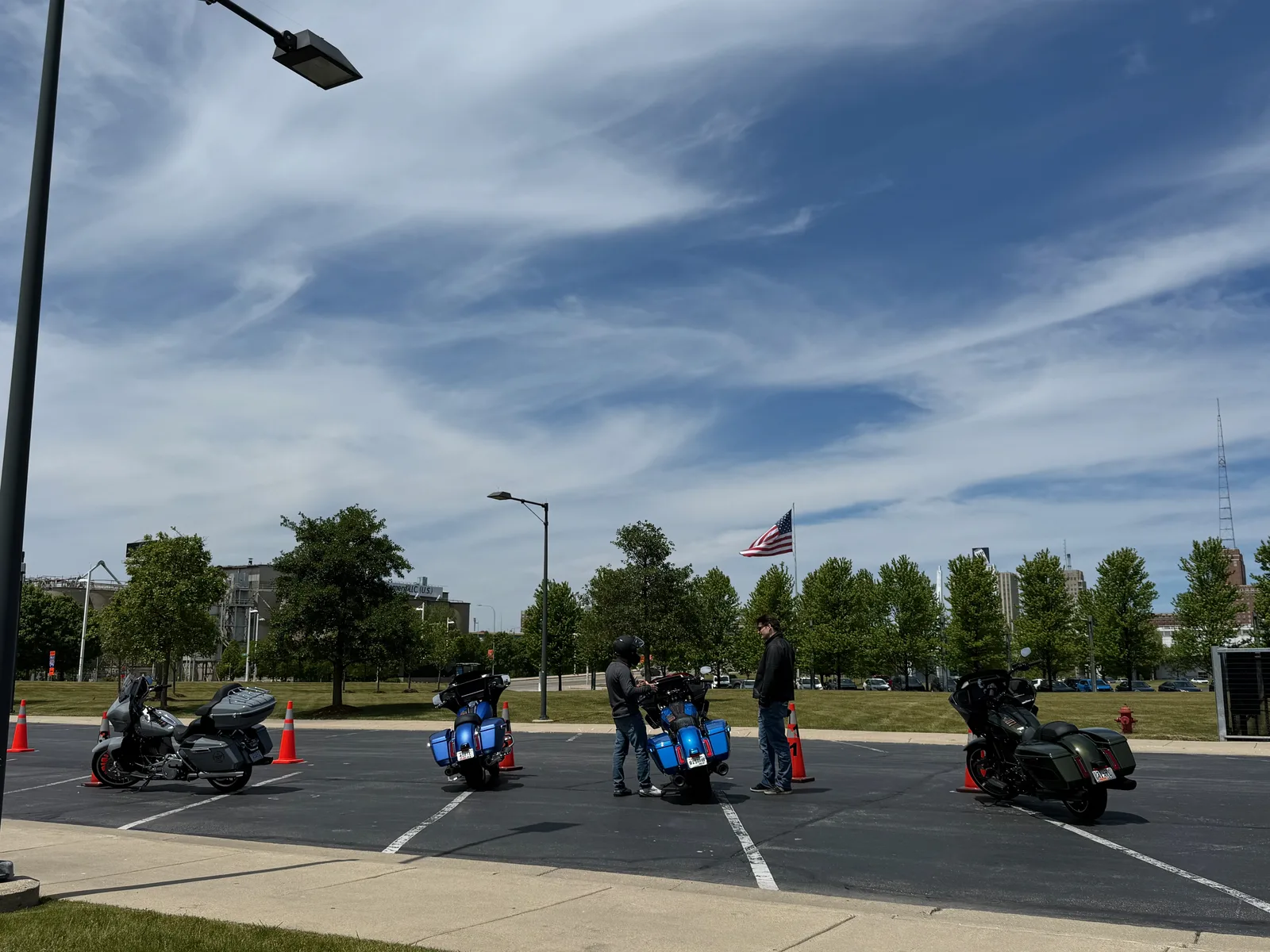 Harley-Davidson demo motorcycles lined up on the pavement in downtown Milwaukee with riders and attendants around them