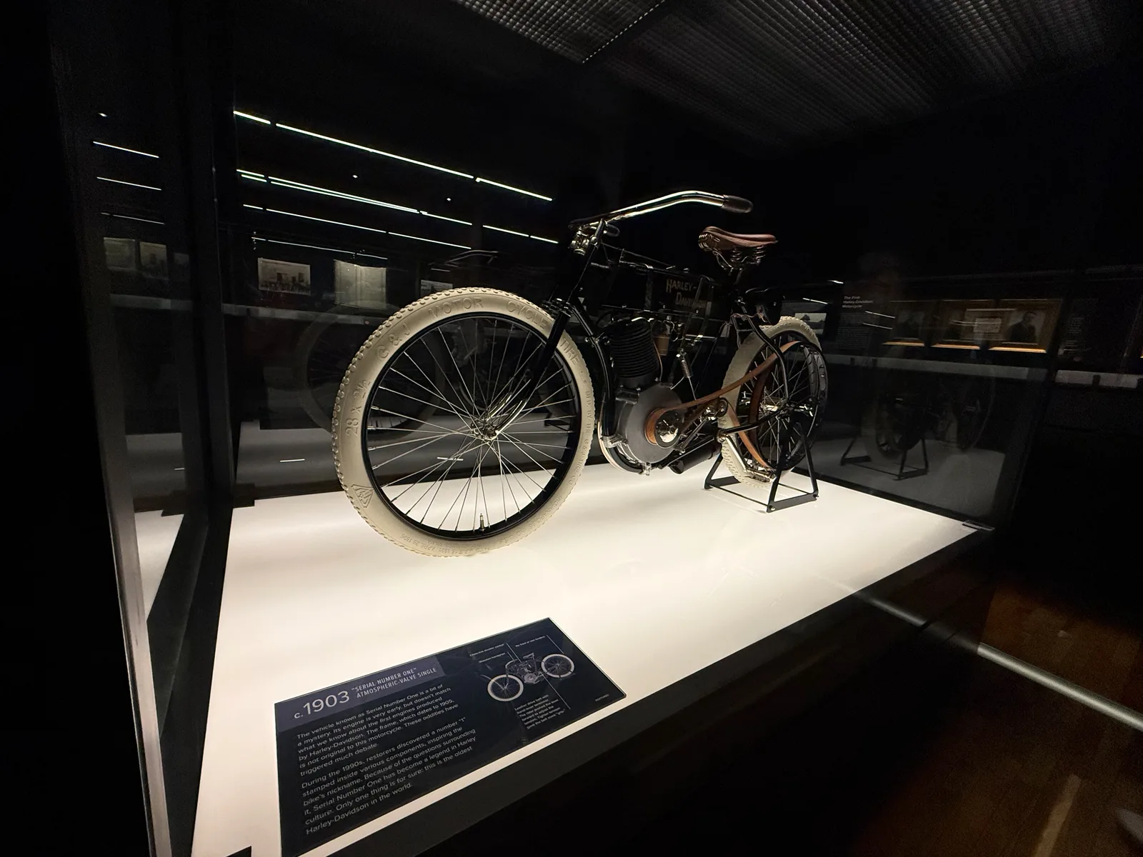 Serial Number One, the c.1903 Harley-Davidson atmospheric-valve single, displayed on a lit white plinth inside a glass vault at the Harley-Davidson Museum