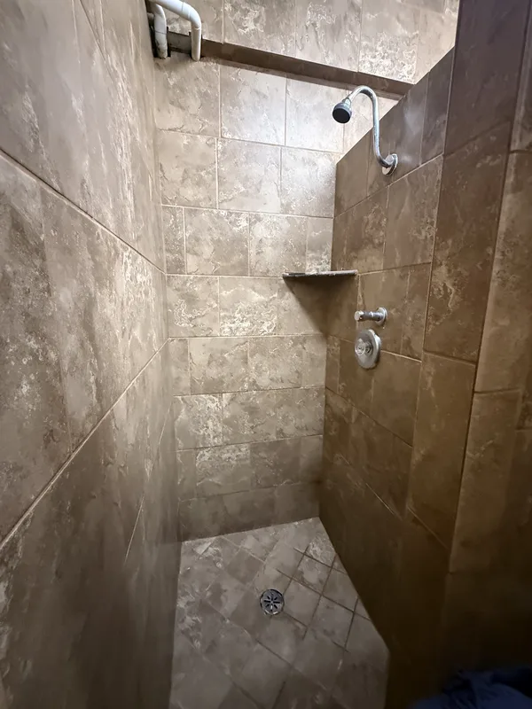 A tiled walk-in shower stall in the updated bathhouse at Campland on the Bay, San Diego