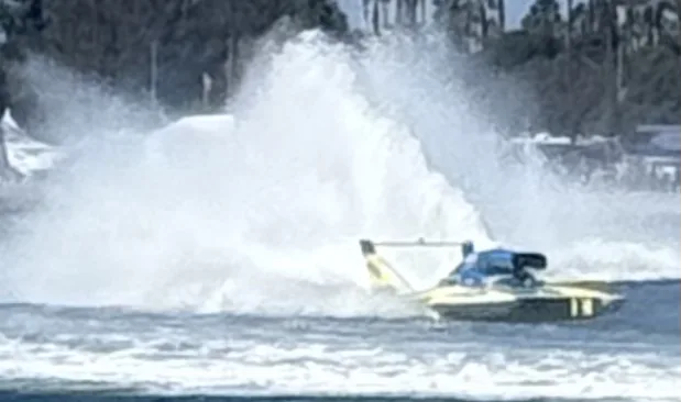 A hydroplane buried in its own spray on Mission Bay during the races, watched from Fiesta Island