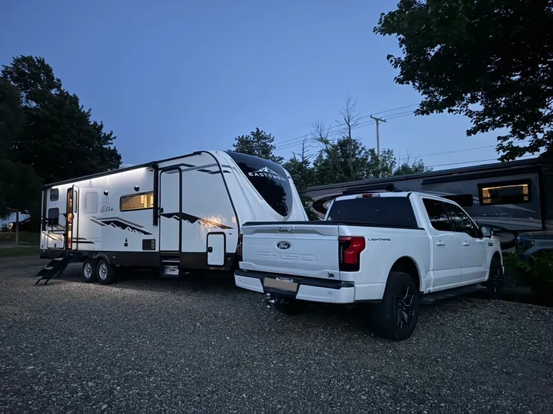 Blue hour at a campground, the East to West Alta lit up behind the rear of the white Ford F-150 Lightning.