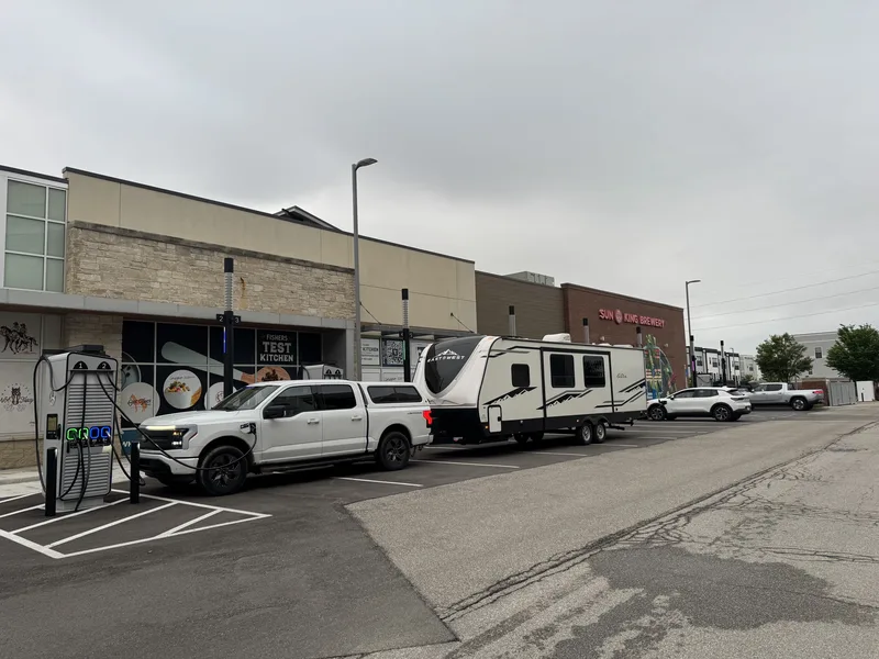 The Ford F-150 Lightning towing the East to West Alta while charging in a downtown lot, a brewery across the way.