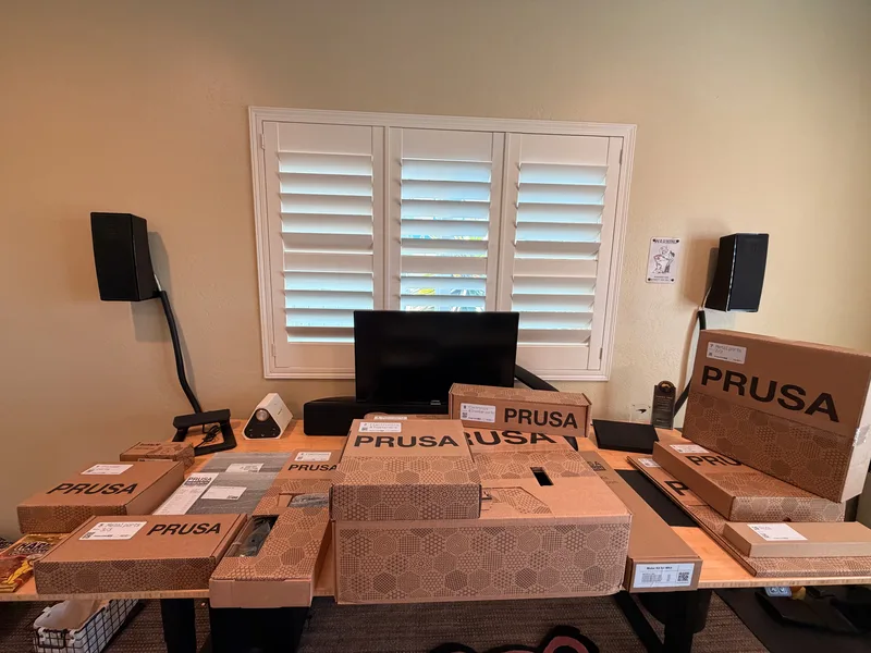 The Wattreach Workshop assembly bench set up by a window with a monitor and parts laid out
