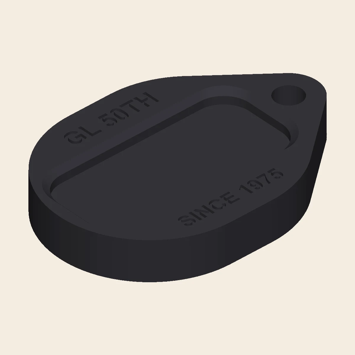 A teardrop-shaped 3D-printed Honda Gold Wing side-stand pad with a recessed foot cradle, GL 50TH and SINCE 1975 etched on top, and a pull tab with a hole